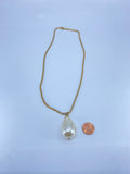 Long gold necklace with a single faux pearl drop.