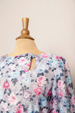 1970's Grey dress with pastel pink, violet & blue roses with a tie keyhole and puff sleeve