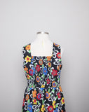 1990's Black sleeveless Plus Size dress with a primary colored flowers, back smocking & 1 pocket