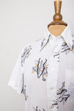 1970's White short sleeve button down shirt with a novelty print of dancing tuxedo guys