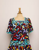 1990's Black Muumuu Midi dress with primary colored celebration confetti print and bell sleeves with pockets