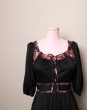 1970's Black prairie style puff sleeve dress with floral trim and corset lacing on bodice