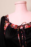 1970's Black prairie style puff sleeve dress with floral trim and corset lacing on bodice