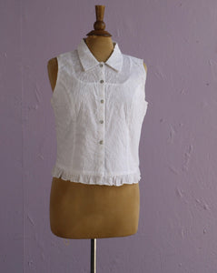 White sleeveless top with floral embroidery.