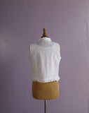 White sleeveless top with floral embroidery.